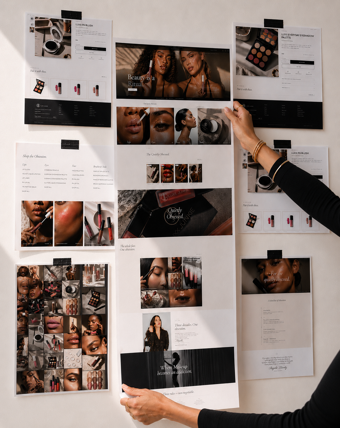 Person arranging promotional materials on a wall with images of people and product packaging.