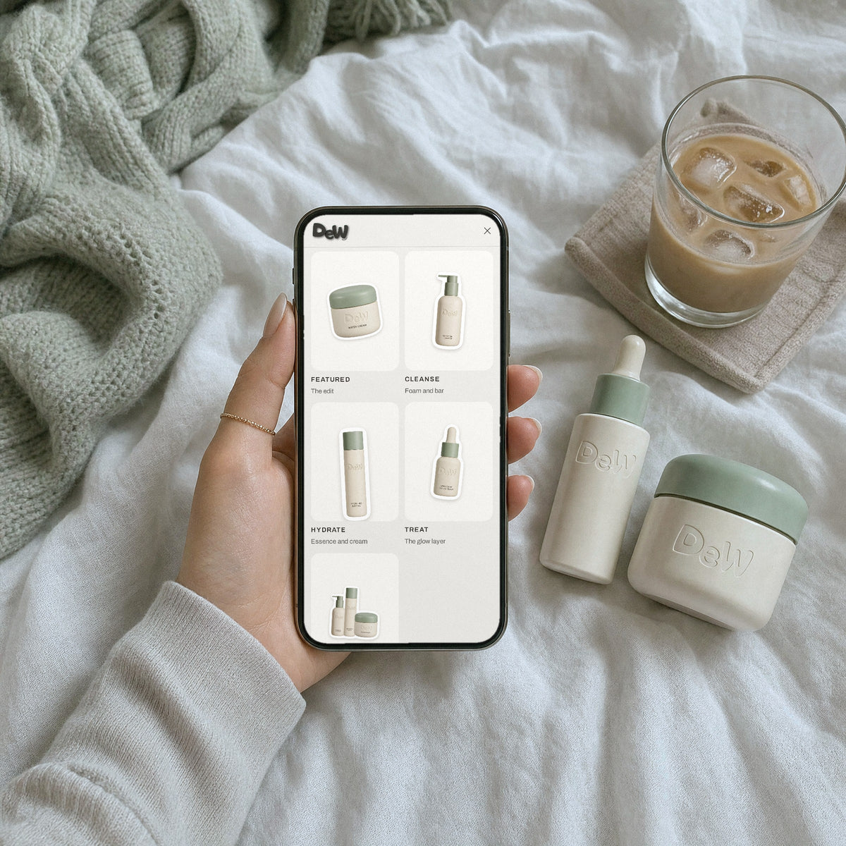 Dew World photo menu on a phone over linen sheets